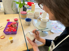 Schichtwechslerin Carola König bemalt eine Tasse
