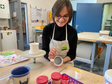 Schichtwechslerin Carola König bemalt eine Tasse